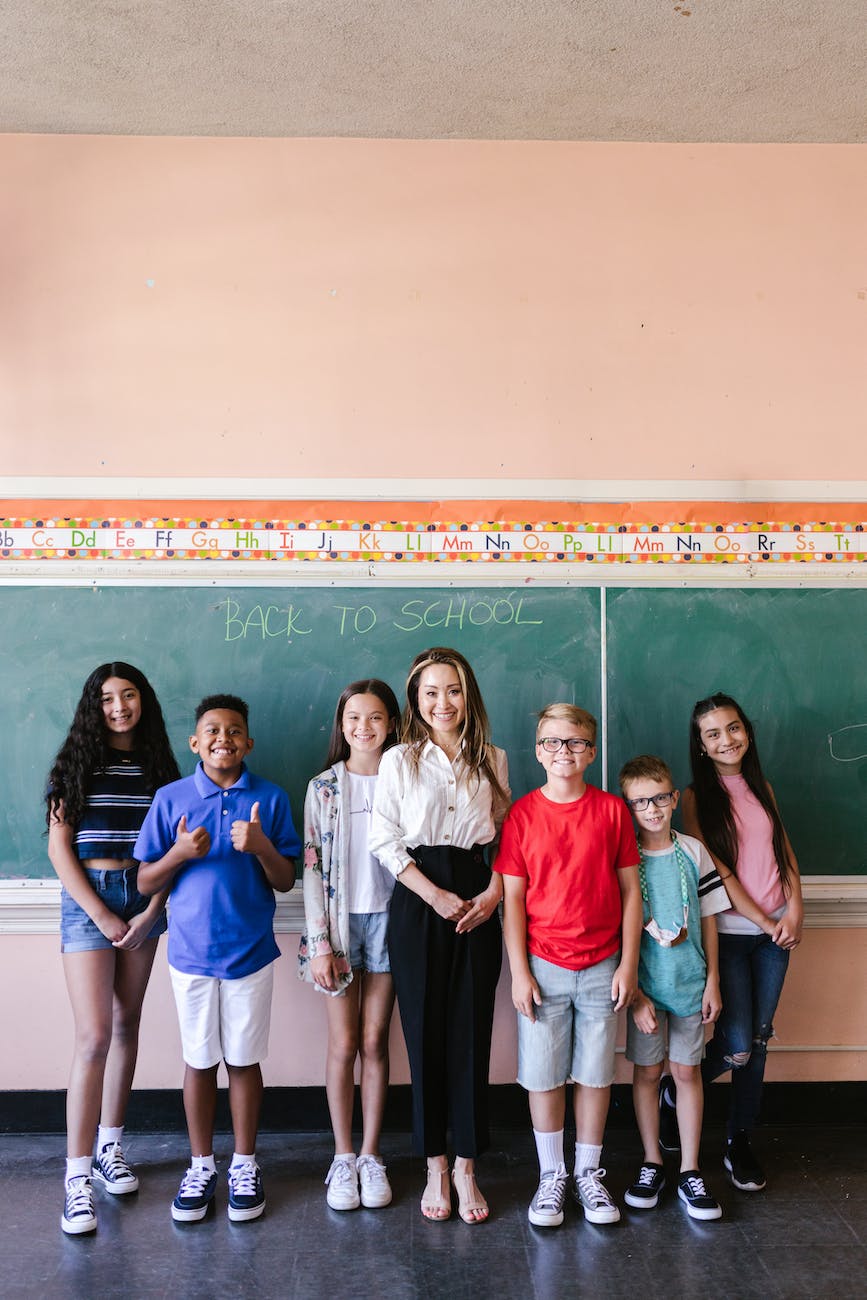 group of people standing beside chalkboard